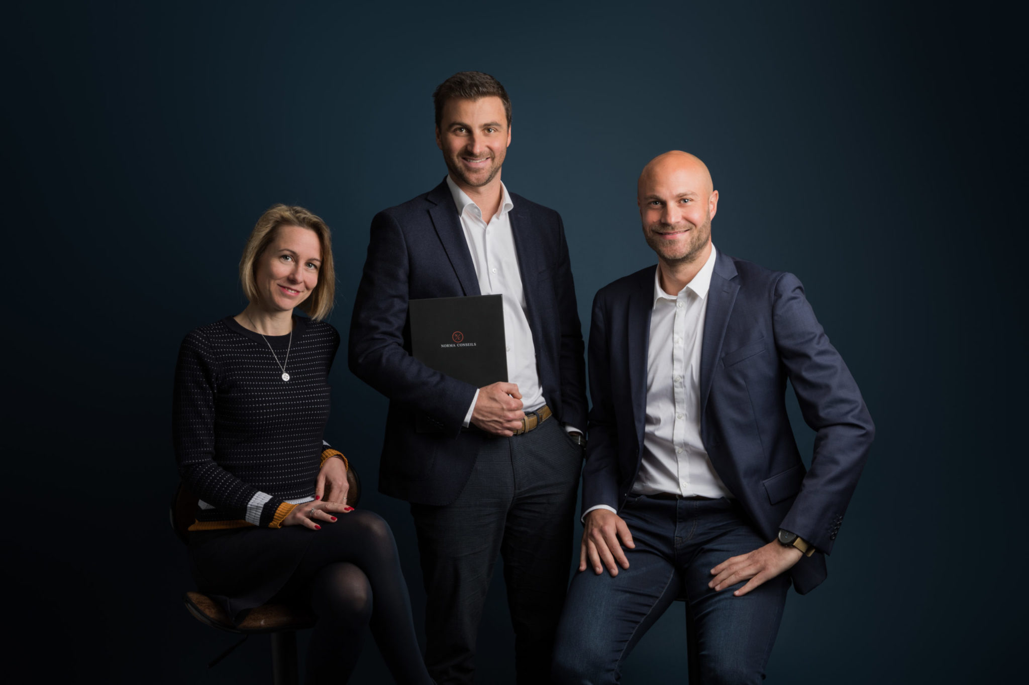 Trois personnes en tenue professionnelle posent ensemble.