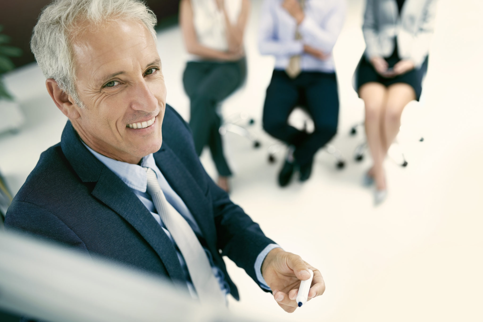Homme souriant en réunion professionnelle.