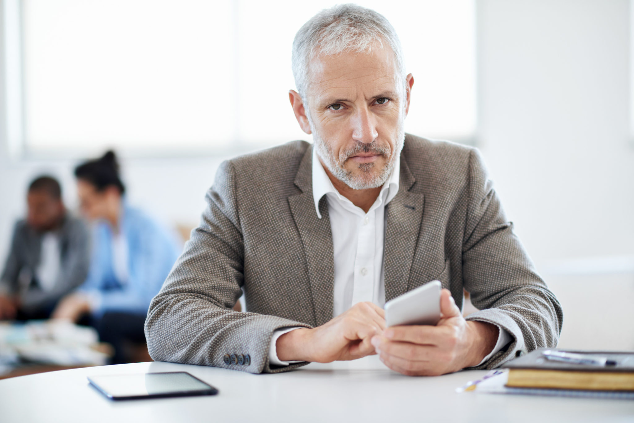 Homme d'affaires sérieux utilise un smartphone.